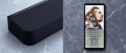 Juoda „Sony“ garso juosta ir išmanusis telefonas su atidarytu garso grotuvu pilko marmuro fone
