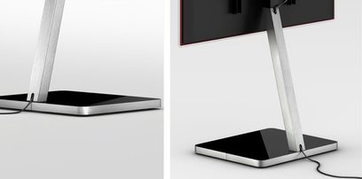Moderne, designmøbel til TV i sort og sølvfarvet metal, med standerfod og sort glashylde, vist forfra og fra siden