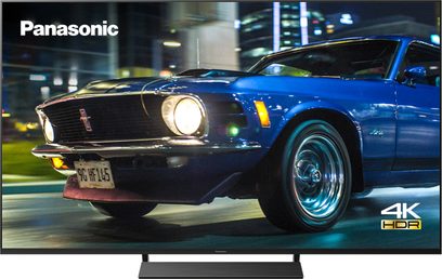 Panasonic TX-50HX800E 4K HDR-fladskærm, der viser en blå Ford Mustang fra 1969 set fra 3/4 forfra på en parkeringsplads om natten