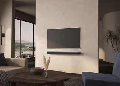 Sonos ARC soundbar zamontowana na ścianie pod płaskim telewizorem w nowoczesnym, minimalistycznym salonie