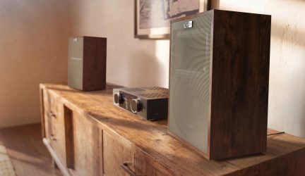 Diffusore da scaffale Klipsch marrone scuro con griglia grigia, visto di tre quarti su un mobile audio