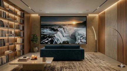 Heimkinowohnzimmer mit großer Projektionsleinwand, die einen Wasserfall zeigt, nachtblauem Sofa, wandfüllendem Bücherregal und Bogenlampen
