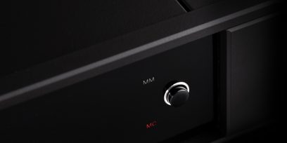 Rega Aria MK3 čierny fonokorektor. Strieborný otočný gombík. Červené nápisy "MM" a "MC" na matnom čiernom prednom paneli