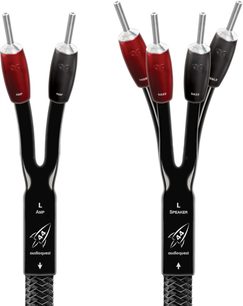 Twee zwarte Audioquest-audiokabels met metalen connectoren, één gemarkeerd als "AMP" en de andere als "SPEAKER", op een witte achtergrond