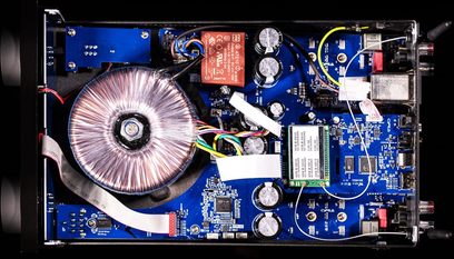 Vue intérieure d'un amplificateur audio Cyrus ONE HD Cast, circuit imprimé bleu avec composants électroniques variés