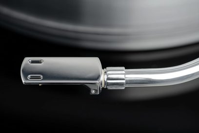 Braço para toca-discos em alumínio em forma de S com uma cabeça retangular prateada e duas fendas retangulares