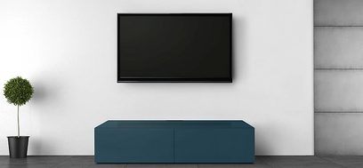 Lav blå andemøbel-TV med 2 døre og sort farve, på lys grå gulv, med grøn plante og sort vægmonteret TV-skærm