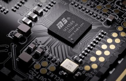 Nærbillede af en STMicroelectronics-chip på et sort printkort med elektroniske komponenter og guldkontakter