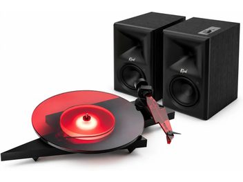 Gramofon z półprzezroczystym czerwonym talerzem i czerwonym ramieniem, z dwiema czarnymi kolumnami Klipsch