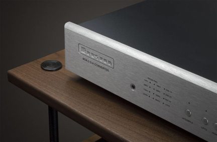 Bryston BDA-3 audio DAC converter with silver brushed aluminum front panel, close-up of the front on a wooden shelf