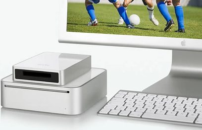 Carcasa multimedia Elgato EyeTV Sat blanca, teclado inalámbrico blanco, vista frontal y lateral, sobre fondo blanco, con jugadores de fútbol en el fondo