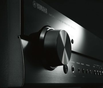 Yamaha RX-S601 Schwarz Heimkino-Verstärker, Nahaufnahme der Frontansicht mit gebürstetem Metallregler und Audio-Anschlüssen auf der Rückseite