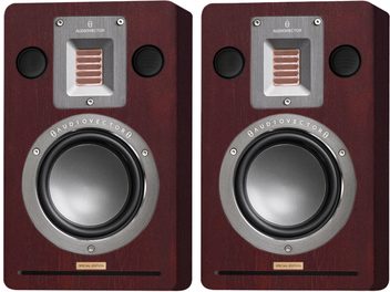 Pair of AudioVector QR Wall SE rear speakers in brown wood with mahogany finish, front view showing a copper ribbon tweeter embedded in a brushed aluminum plate, two small circular tweeters with black grilles, a large woofer with an aluminum surround, and a lower slotted port