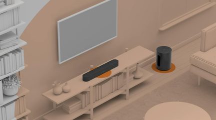 Açık renk ahşap mobilya üzerinde mat siyah soundbar, yandan bass refleksli silindirik siyah subwoofer, üstten görünüm