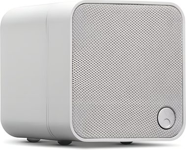 Compacte witte subwoofer met afgeronde hoeken, frontrooster van gaas, driekwartaanzicht