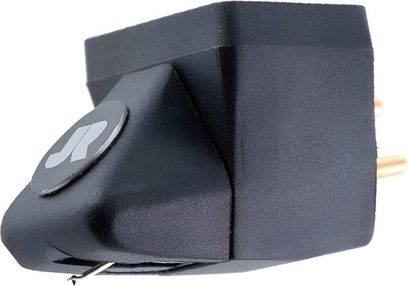 Testina phono nera in plastica testurizzata con disco logo grigio sul lato, puntina di lettura metallica sotto la parte anteriore e due pin dorati sul retro, vista laterale in primo piano