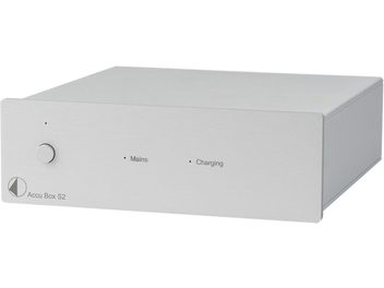 Отделен захранващ блок за HI-FI електроника Accu Box S2, правоъгълен метален корпус в сребрист цвят, кръгъл бутон отляво, два светлинни индикатора и надписи "Mains" и "Charging" на предната страна, перспективен изглед с леко наклонена позиция