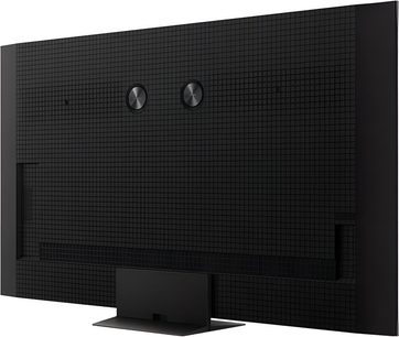 Televizor TCL 65C8K v černé barvě s vysokým rozlišením, zadní část z plastu s čtvercovým vzorem, dvěma kovovými kruhovými disky a centrálním obdélníkovým stojanem, pohled ze tří čtvrtin zezadu