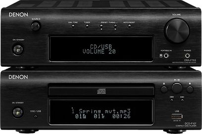 To sorte Denon D-F107 Hi-Fi mini-anlæg, set forfra, hvor det ene viser "CD/USB VOLUME 20", og det andet viser "Spring nut.mp3 01A 01:00:25"
