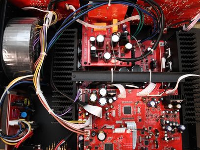 Vista interna di un amplificatore hi-fi stereo Advance Paris A10 nero che mostra circuiti elettronici rossi e componenti