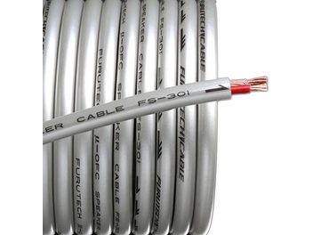 Câble Furutech FS-301 gris clair, gaine transparente laissant voir des inscriptions, posé sur des câbles blancs, vue rapprochée
