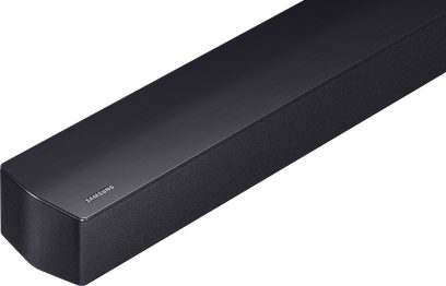 Svart Samsung HW-B460F soundbar, lång rektangulär enhet med ovansida i borstat metall och front samt sidor täckta av ett nätliknande tyg, sedd i trekvarts vinkel