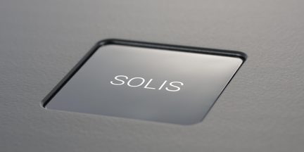 Pulsante quadrato SOLIS grigio scuro incassato in una superficie opaca, vista in primo piano