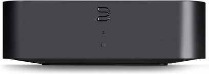 Μαύρος δικτυακός αναπαραγωγέας ήχου BlueSound HUB, μετωπική όψη, στρογγυλεμένο ορθογώνιο σχήμα, ανάγλυφο χρωμιωμένο λογότυπο "b"
