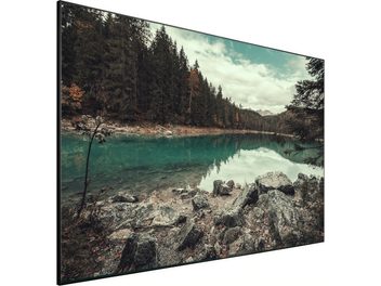 Lumene Movie Palace UHD 4K Ultraslim 300C fastrammet skærm, der viser et efterårslandskab med skov og sø med klipper i forgrunden