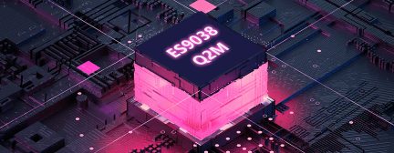 Lysende rød terningformet objekt med teksten "ES9038 Q2M" på et printplade med elektroniske komponenter, set fra et luftperspektiv