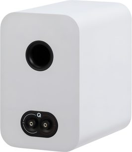 Q Acoustics 3020c white bookshelf speaker in matte wood finish, rear three-quarter view showing black circular bass-reflex port and connection plate with two terminals