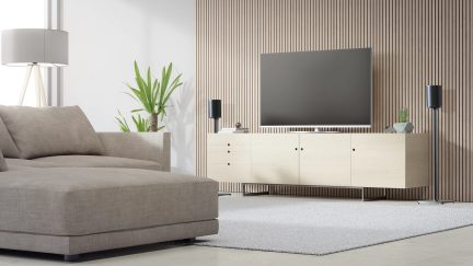 Lys grå sofa og hvidt TV-møbel med hylder i en moderne stue med hvide vægge med lodrette striber