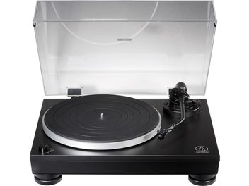 Audio Technica AT-LP5X black turntable, front view with transparent dust cover open, placed on a black plinth
