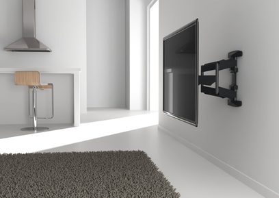 Vægmonteret sort TV på hvid væg i et rum med gråt gulv, vægklistermærke og soundbar på lys træhylde