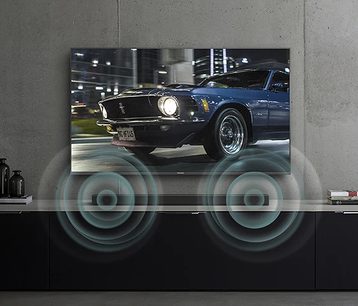 Modrý Ford Mustang z roku 1970, pohled z levé přední strany v úhlu 3/4, rozsvícená přední světla, na černém pozadí s odlesky světla