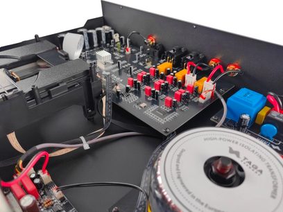 Lettore CD hi-fi TCD-70T argento, vista interna con angolazione inclinata, circuiti stampati neri con componenti rossi, gialli, neri, condensatori cilindrici, trasformatore circolare con testo visibile, cavi collegati