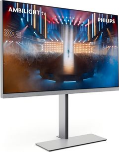 Televisore ad alta definizione Philips 65OLED959 nero con cornice ultrasottile, soundbar integrata in tessuto grigio, montato su base centrale in metallo argentato, vista da tre quarti anteriore sinistra