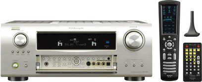 Sølvfarvet Denon AVR-2809 hjemmebiografsforstærker set forfra med fjernbetjening, blåt display, knapper og tilslutninger