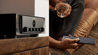 Μαύρος στερεοφωνικός ενισχυτής hi-fi Marantz Model 40n, τηλεχειριστήριο, χέρι που κρατά ποτήρι ουίσκι, κοντινή μπροστινή άποψη