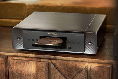 Lecteur CD Marantz CD60 noir, vue de face, posé sur un meuble en bois, façade noire avec écran et bouton lecture