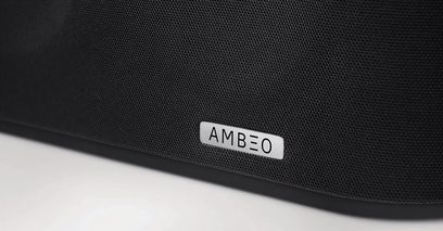 Dettaglio di una soundbar nera con il logo "AMBEO" in lettere bianche sulla griglia frontale in tessuto
