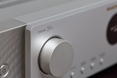 Marantz Cinema 70s gümüş renkli ev sineması amplifikatörü, ön panel yakın çekimi, ses düğmesi ve model yazısı
