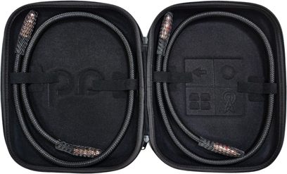 Cabluri audio RCA Audioquest Black Beauty cu înveliș împletit negru aranjate în buclă într-o husă rigidă deschisă