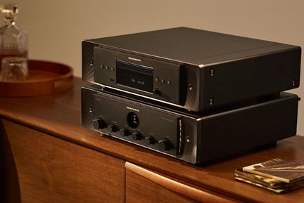 Δύο μαύρες μεταλλικές συσκευές hi-fi Marantz, με αναπαραγωγέα CD με οθόνη πάνω και ενισχυτή με κουμπιά κάτω, σε προβολή τρία τέταρτα