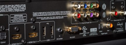Bagpanel på en sort elektronisk enhed med mange farvede audio- og videostik, USB-porte og HDMI-porte