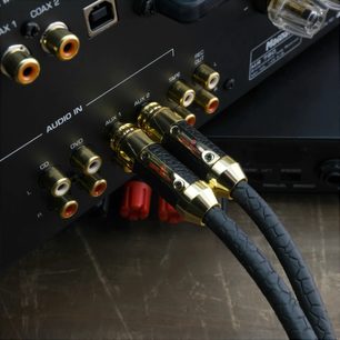Cyfrowy kabel koncentryczny Oehlbach Black Connection digital 2 m, czarny z teksturowaną osłoną, wyposażony w pozłacane metalowe złącza RCA, widok z trzech czwartych, wpięty w gniazda audio wzmacniacza