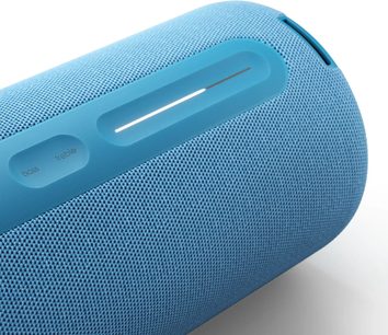 Prenosni Bluetooth zvočnik Loewe We. HEAR pro modre barve, bližnji pogled s teksturirano rešetko in vgrajenimi upravljalnimi elementi