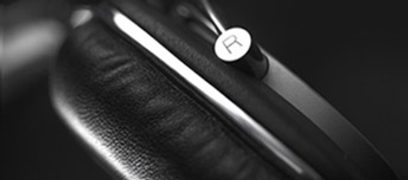 Bowers & Wilkins P5 sort hovedtelefoner, nærbillede af hovedbøjlen og den højre ørekop med hvidt "B"-logo