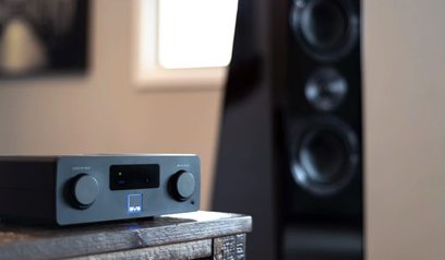 Bezdrátový audio přenos SVS Prime SoundBase tmavě šedý, pohled zepředu, položený na tmavém dřevěném povrchu