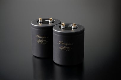 Accuphase P-7500, to sorte cylindriske kondensatorer, perspektivisk visning, gyldne terminaler på toppen, glat overflade